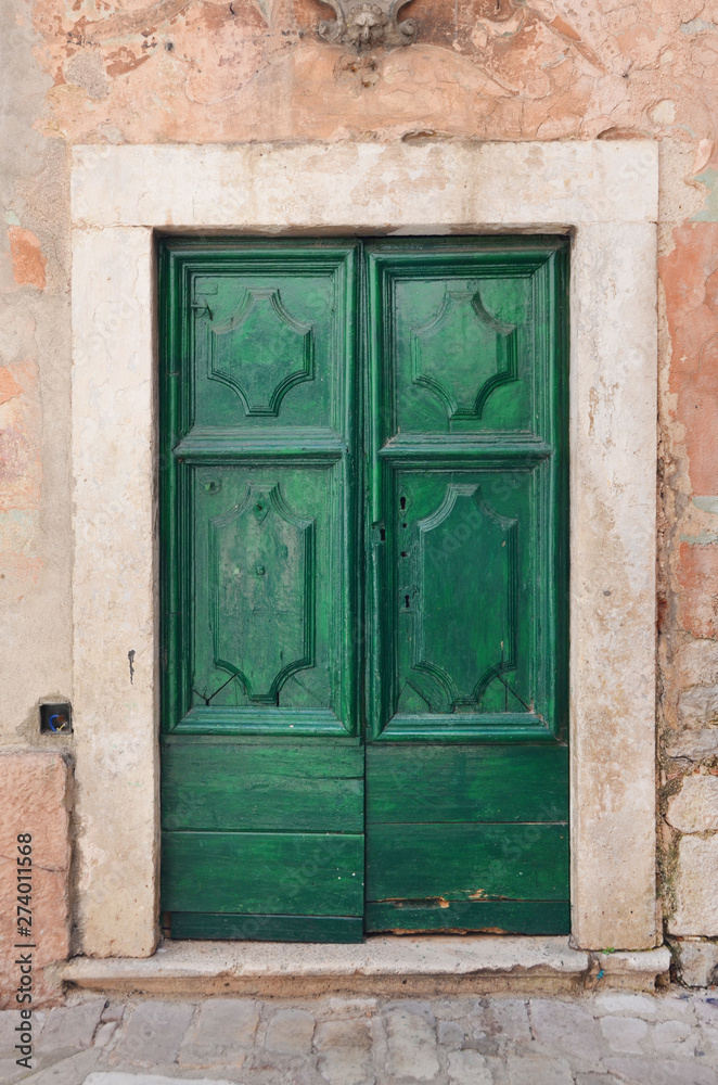 Od green door on an old medieval building. Od green door on an old medieval building.