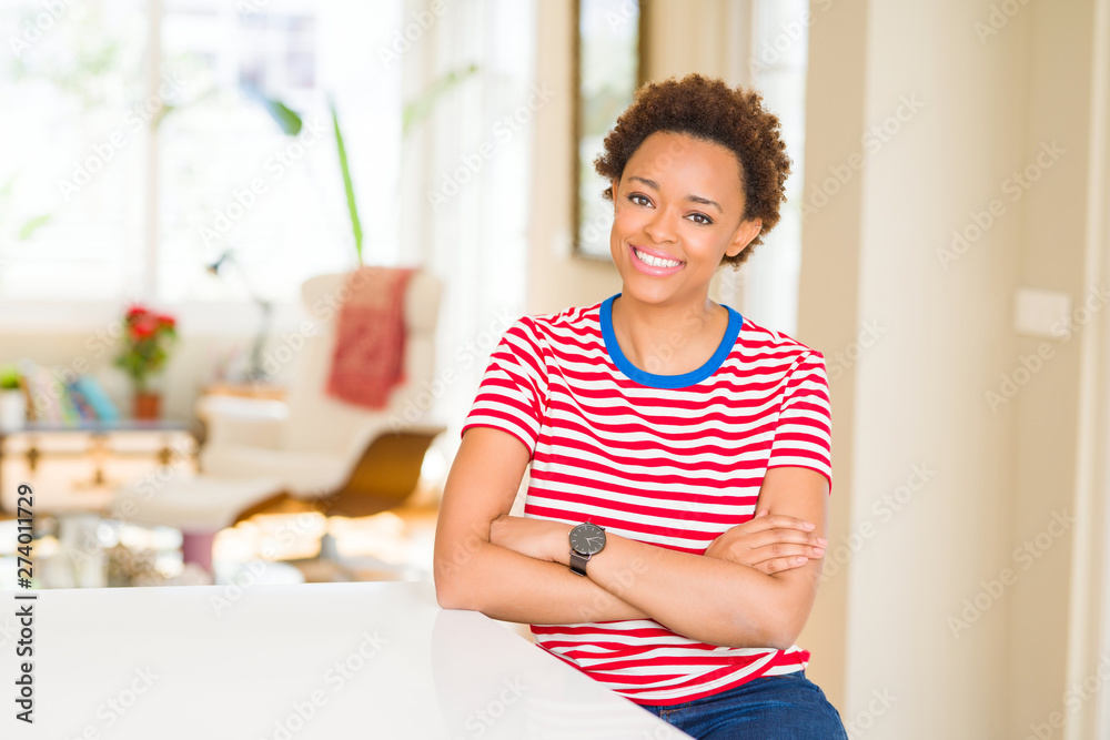 Young beautiful african american woman at home happy face smiling with crossed arms looking at the camera. Positive person. Young beautiful african american woman at home happy face smiling with crossed arms looking at the camera. Positive person.