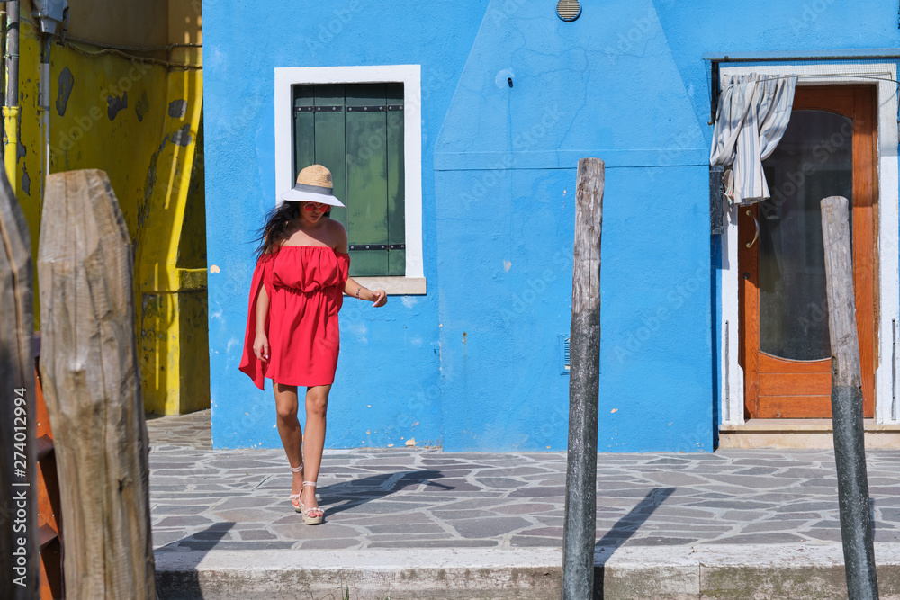 happy tourist woman posing among colorful houses on Burano island, Venice. Tourism in Italy concept