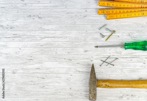 Bild auf Leinwand Hand tools on a white wooden background, hammer with nails and a folding rule, n