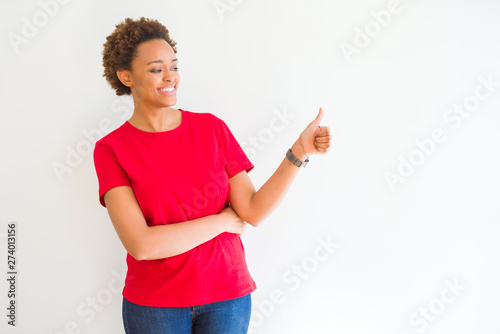 Young beautiful african american woman over white background Looking proud, smiling doing thumbs up gesture to the side