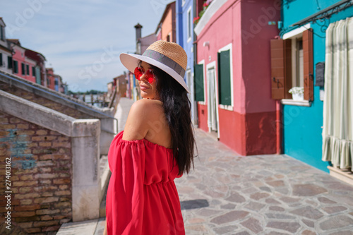 traveler woman posing among colorful houses on Burano island, Venice. Tourism in Italy concept