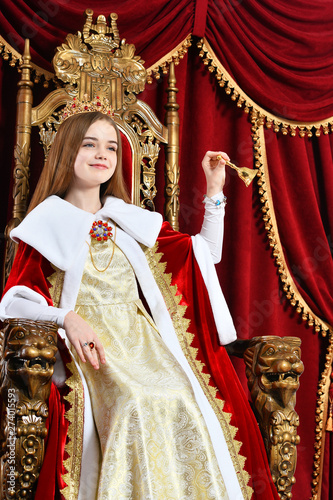 Portrait of beautiful princess with crown holding hand bell