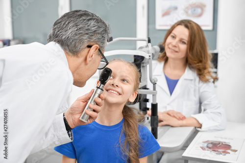 Smiling girl checking vision in laboratory