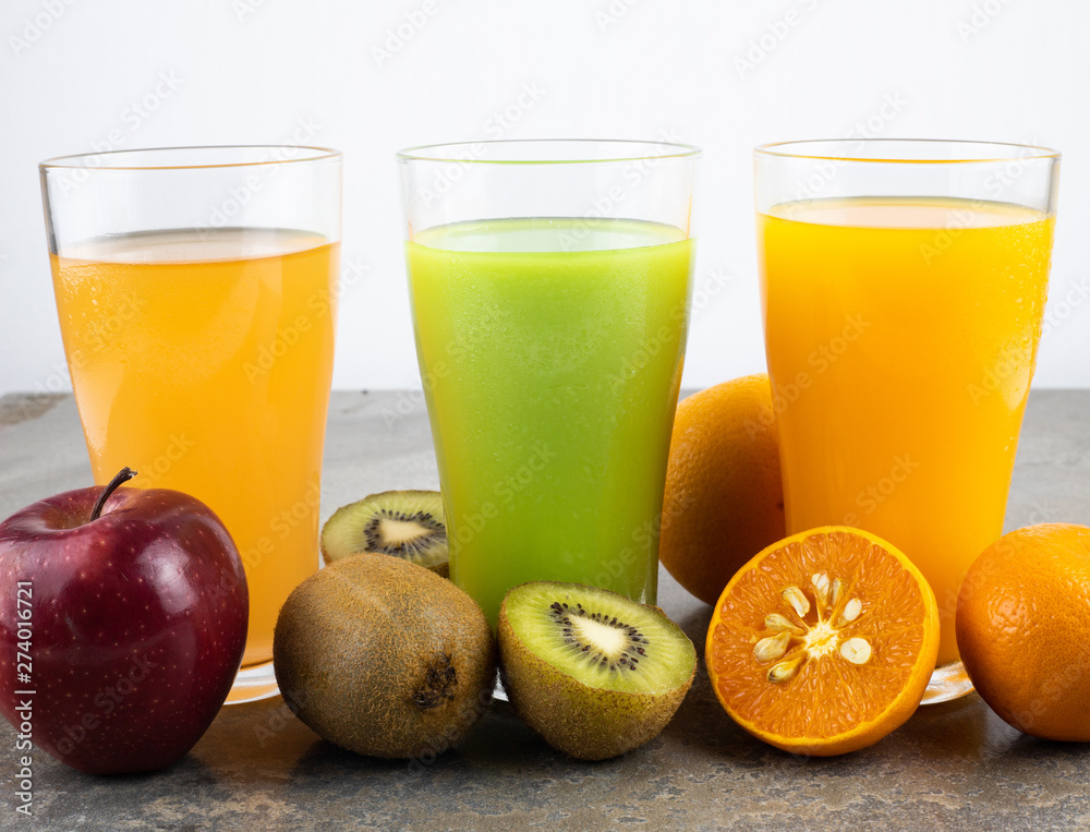 Juices of apple, kiwi orange in a glass. Juices of apple, kiwi orange in a glass.