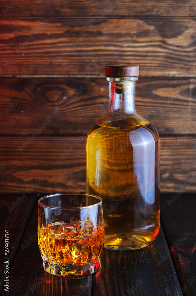 Bottle of whiskey on a wooden background.Studio photography. Bottle of whiskey on a wooden background.Studio photography.