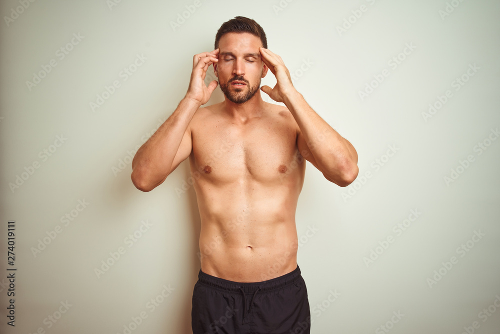 Fototapeta premium Young handsome shirtless man over isolated background with hand on head for pain in head because stress. Suffering migraine.