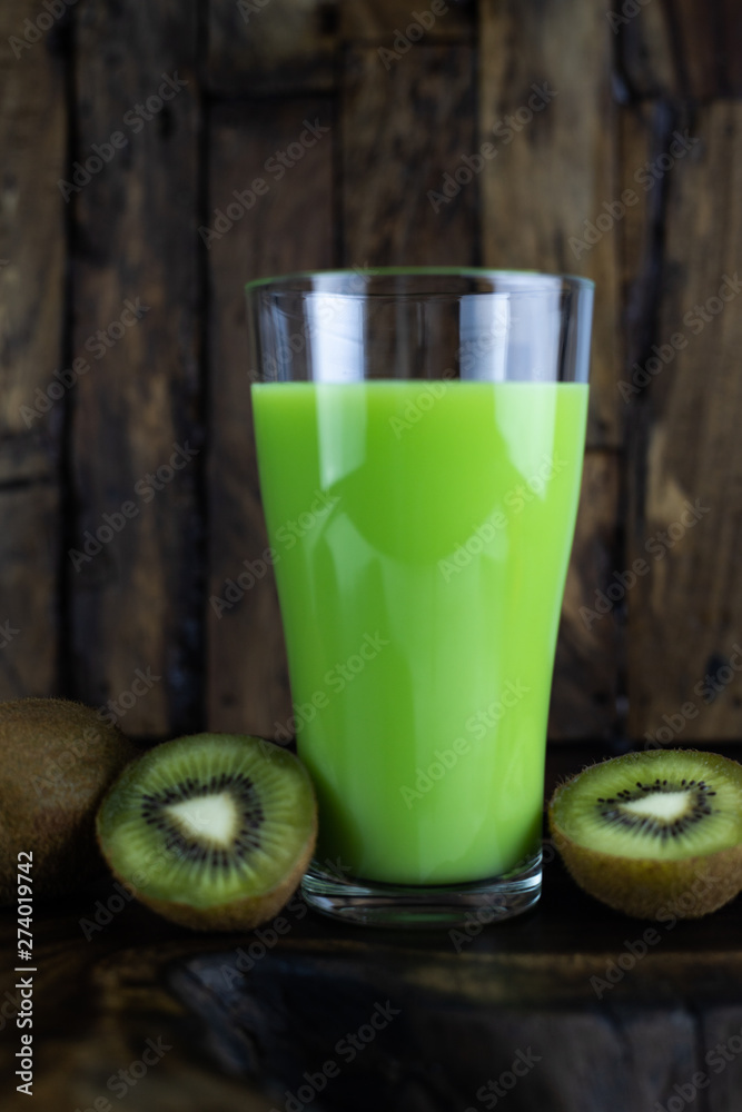 Still life photo of kiwi juice, kiwi smoothie in a glass on wooden background. Still life photo of kiwi juice, kiwi smoothie in a glass on wooden background.