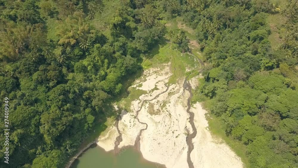 Top view from drone riverbed and lake shore on rainforest and green mountains landscape. Aerial landscape tropical river in rainforest on green mountain on cloudy sky background. Top view from drone riverbed and lake shore on rainforest and green mountains landscape. Aerial landscape tropical river in rainforest on green mountain on cloudy sky background.