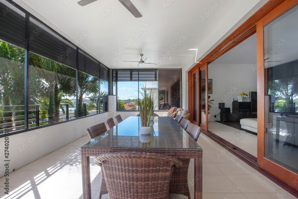 Φωτογραφία Outdoor dining table near the window over looking the neighborhood with two potted plants above the table and ceiling fan