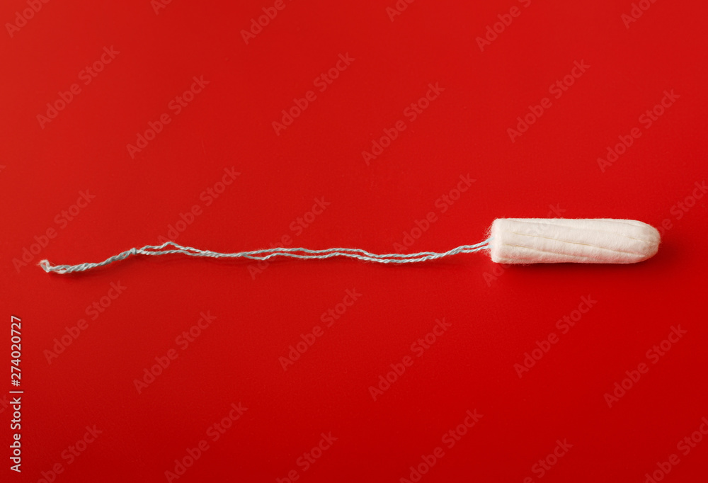 Medical female tampon on a pink background. Hygienic white tampon for women. Cotton swab. Menstruation, means of protection. Tampons on a red background.