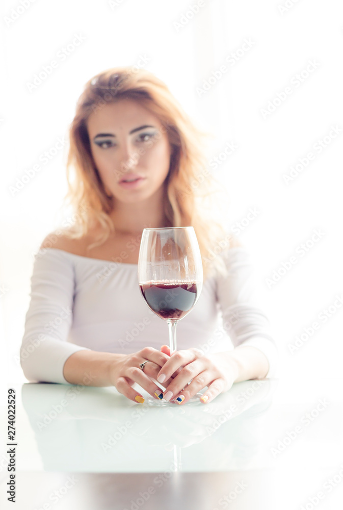 Young beautiful woman with glass of red wine on light background Young beautiful woman with glass of red wine on light background