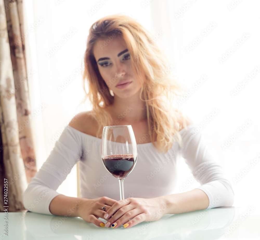 Young beautiful woman with glass of red wine on light background Young beautiful woman with glass of red wine on light background
