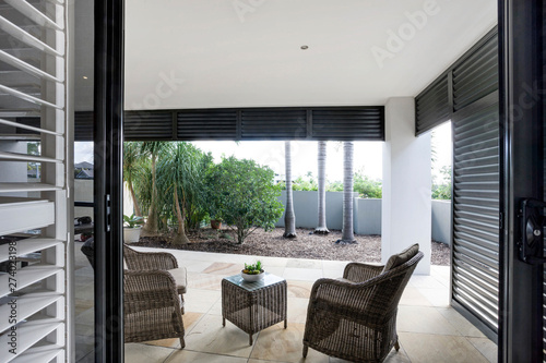 Two wooden chairs facing the landscaped lawn.