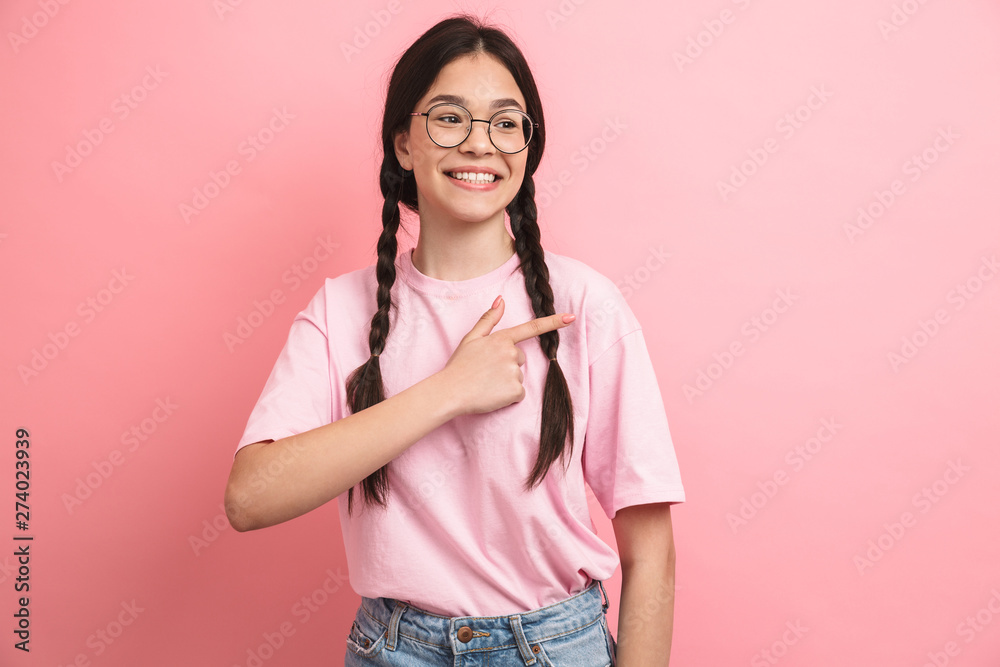Image closeup of beautiful happy girl with two braids wearing eyeglasses smiling and pointing fingers aside at copyspace Image closeup of beautiful happy girl with two braids wearing eyeglasses smiling and pointing fingers aside at copyspace