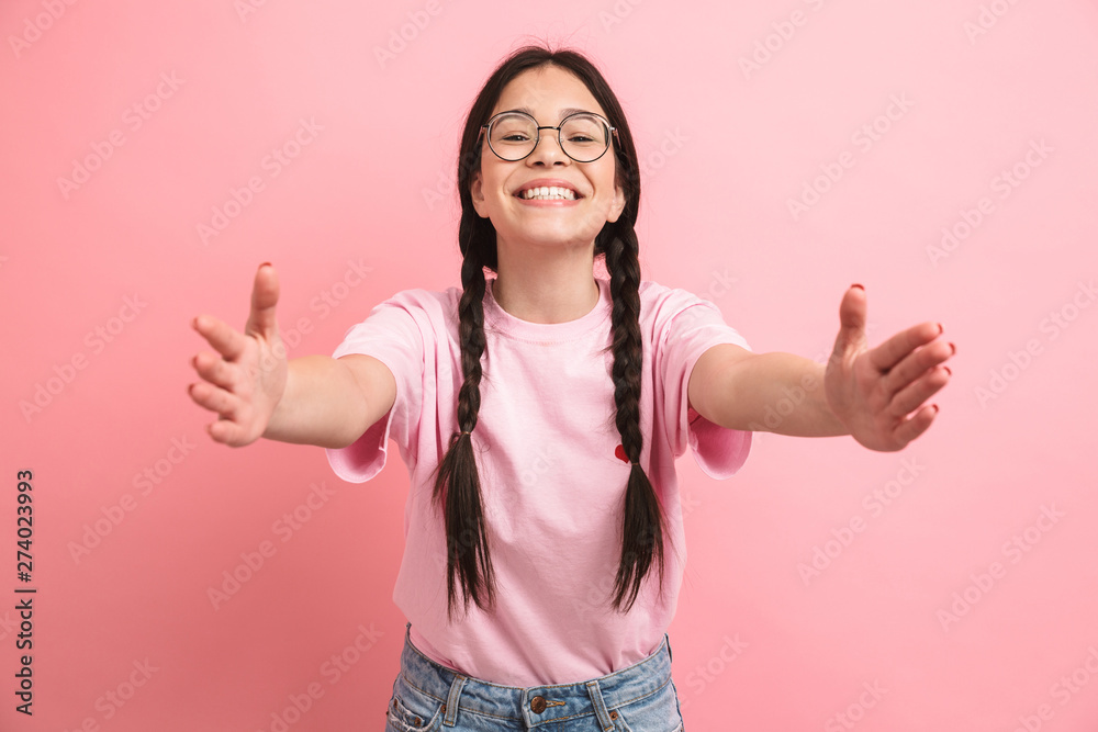 Image of cute european girl with two braids wearing eyeglasses smiling and reaching her arms forward at camera - obrazy, fototapety, plakaty 
