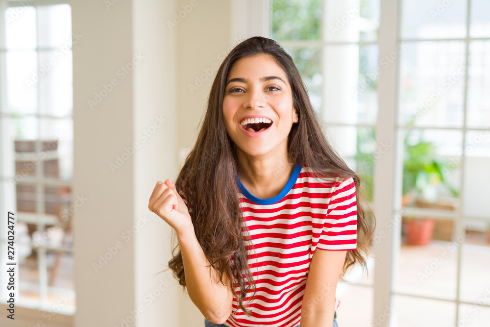 Beautiful young woman celebrating excited for success, screaming and smiling for winning Beautiful young woman celebrating excited for success, screaming and smiling for winning