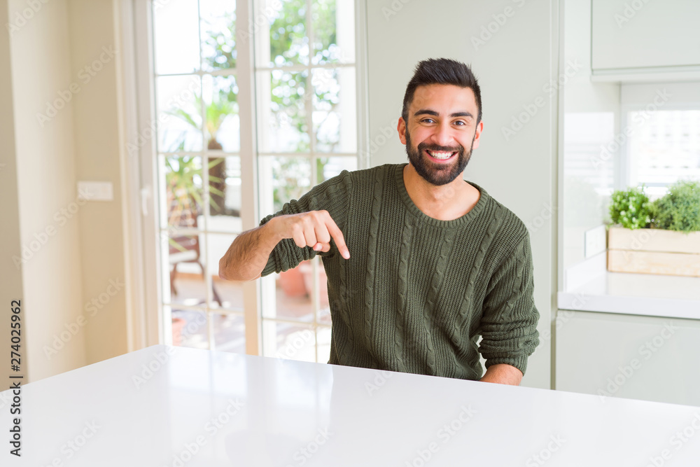 Handsome man pointing with arms and fingers, smiling cheerful with big smile on face