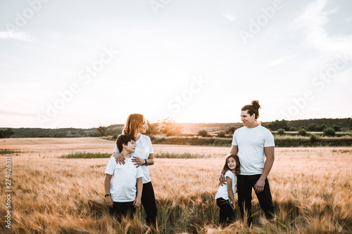 Funny happy family smiling in the field sunset