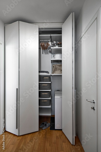 interior shot of a  catchall with a wahite closet whose floor is made of wood