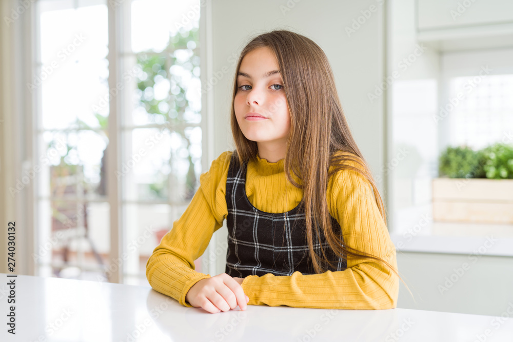 Young beautiful blonde kid girl wearing casual yellow sweater at home Relaxed with serious expression on face. Simple and natural looking at the camera.