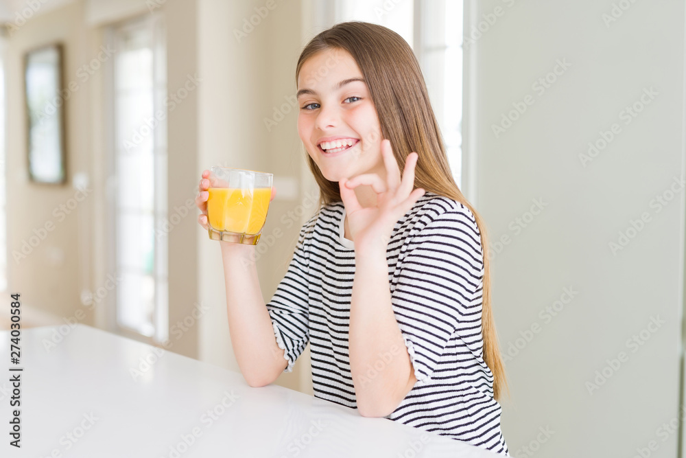 Beautiful young girl kid drinking a glass of fresh orange juice doing ok sign with fingers, excellent symbol Beautiful young girl kid drinking a glass of fresh orange juice doing ok sign with fingers, excellent symbol