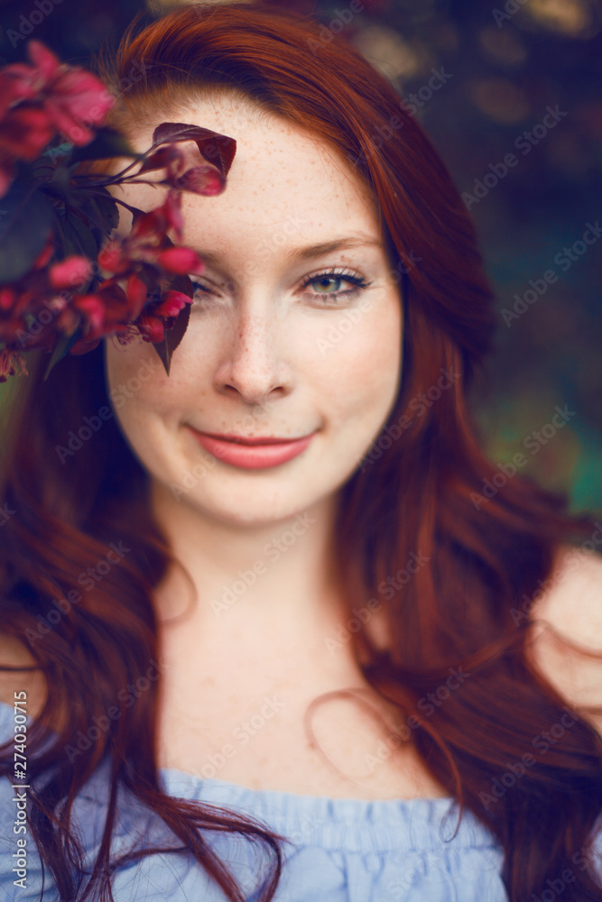 Model with red hair posing in a blooming apple tree. Model with red hair posing in a blooming apple tree.