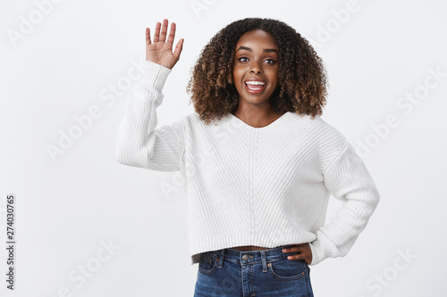 Charismatic friendly sociable lively african-american attractive woman say hi waving raised hand hello gesture greeting friend see familiar person crowd surprise wanna communicate, white background photo