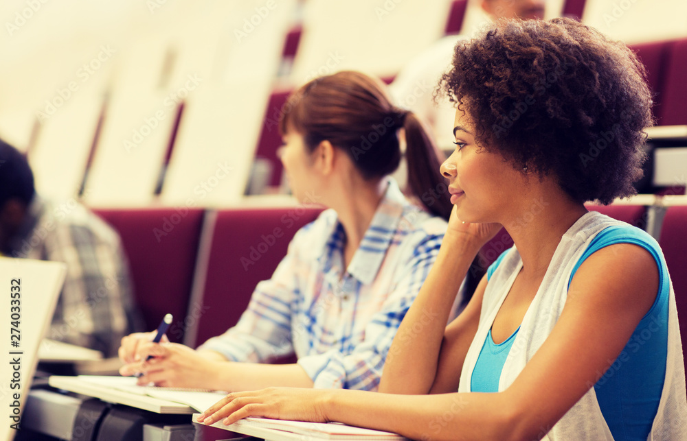 education, high school, university, learning and people concept - group of international students talking in lecture hall education, high school, university, learning and people concept - group of international students talking in lecture hall