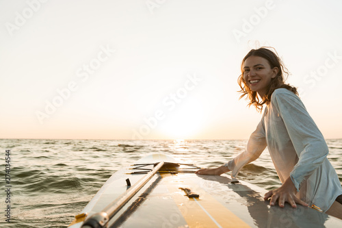 Valokuva Beautiful smiling young woman using a stand up paddle board