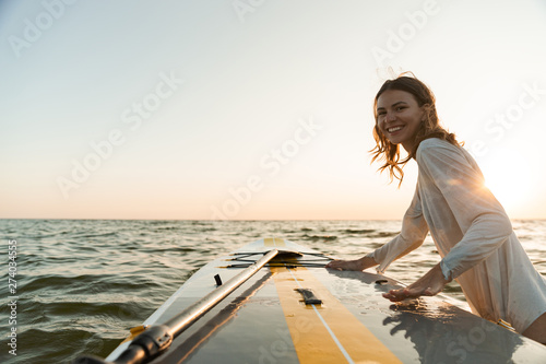 Valokuva Beautiful smiling young woman using a stand up paddle board