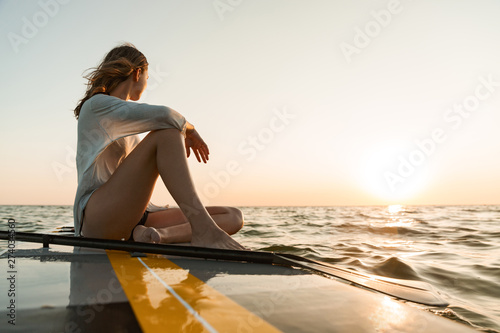 Принти на полотні Beautiful young woman sitting on a stand up paddle board