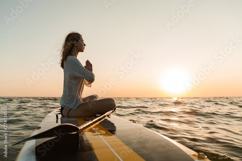 Valokuva Beautiful young woman sitting on a stand up paddle board