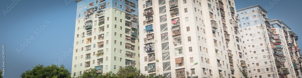 Panoramic lookup typical condos with hanging clothes over blue sky in Hanoi, Vietnam