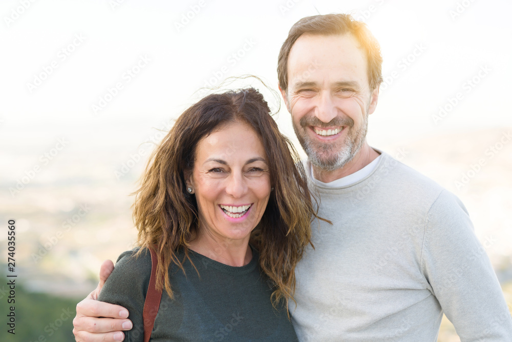 Romantic couple smiling and cuddling on a sunny day - obrazy, fototapety, plakaty 
