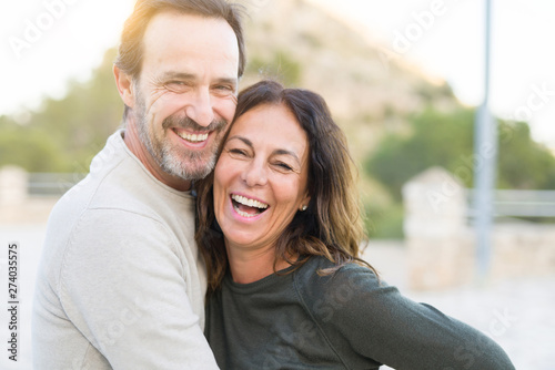 Romantic couple smiling and cuddling on a sunny day