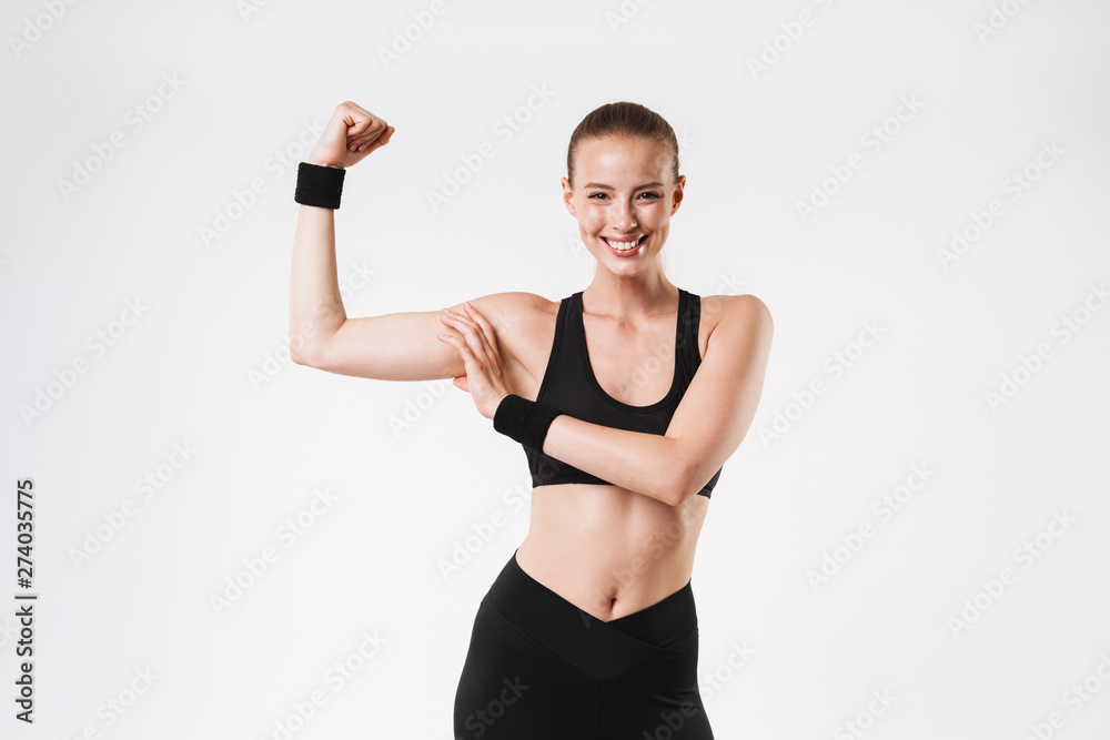 Image of nice sporty woman wearing tracksuit showing and touching her biceps Image of nice sporty woman wearing tracksuit showing and touching her biceps