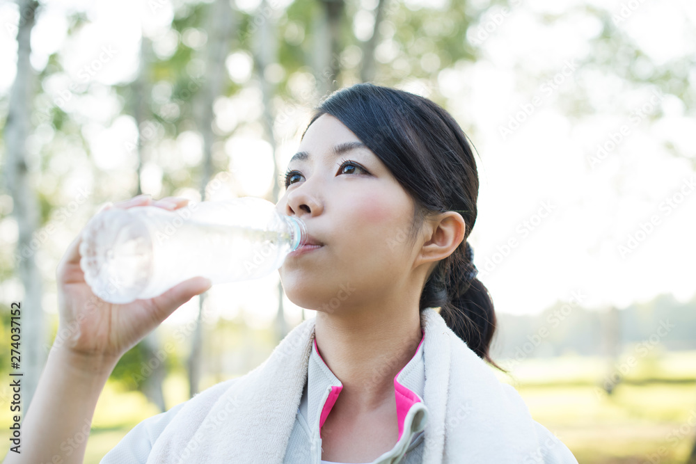 自然の中で水分補給をする女性