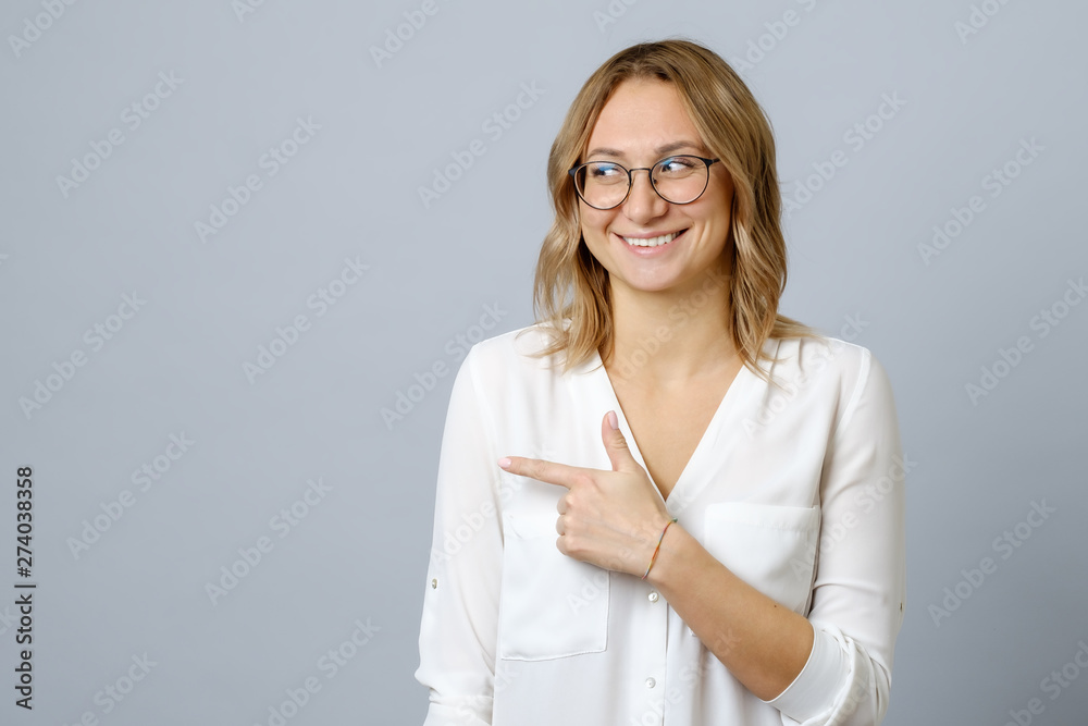 Portrait of a happy young woman pointing fingers away Portrait of a happy young woman pointing fingers away