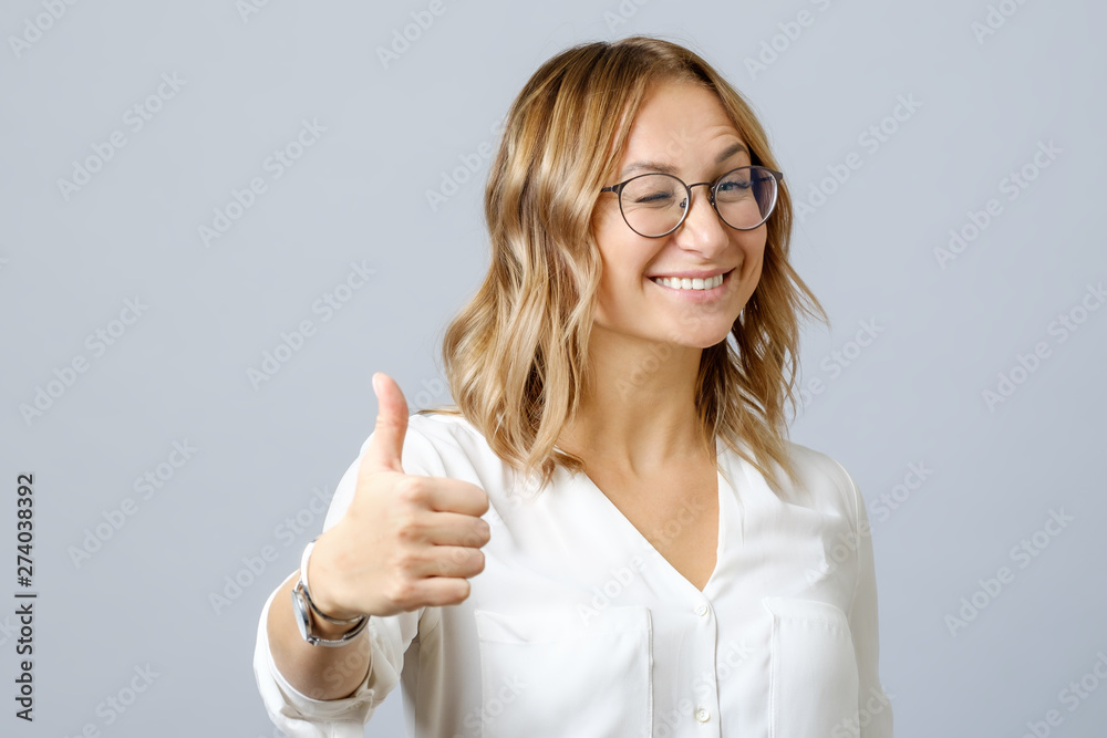 Young happy smiling cheerful woman showing thumbs up Young happy smiling cheerful woman showing thumbs up