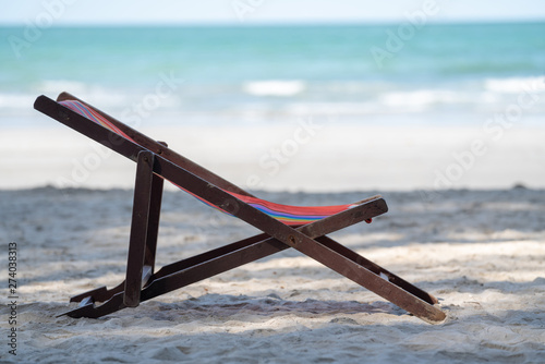 Selective focus of empty beach chair or sunbed on the beach in tropical island in hot summer sunny day.