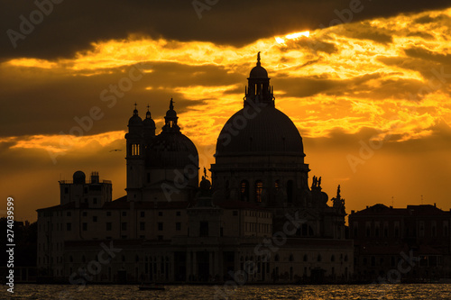 Mysterious and beautiufl sunset over Salute Basilica (Saint Mary of Health) old domes in Venice