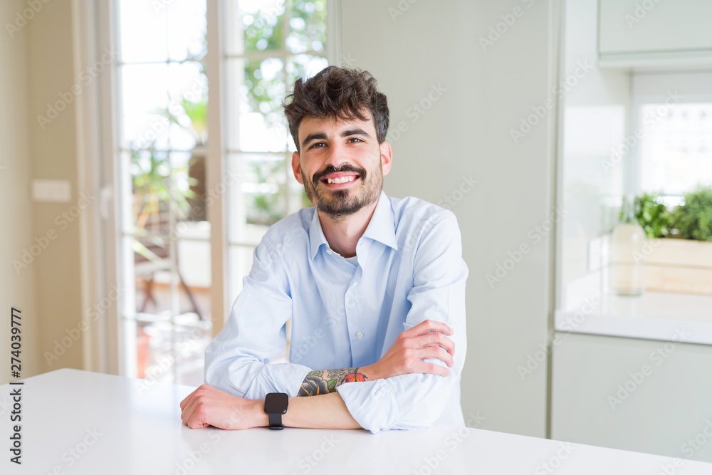 Handsome young business man smiling cheerful at the camera with crossed arms and a big smile on face showing teeth Handsome young business man smiling cheerful at the camera with crossed arms and a big smile on face showing teeth