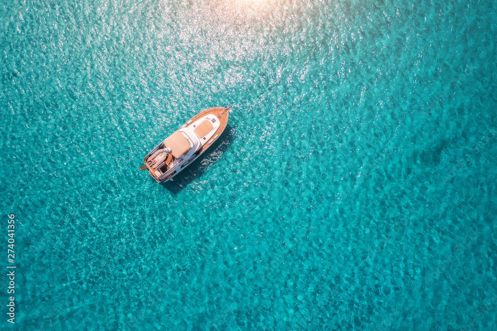 Aerial view of luxury yacht in transparent blue sea at sunny day in summer in Mallorca, Spain. Colorful landscape with boat, bay, clear azure water. Top view from air. Travel. Seascape with motorboat Aerial view of luxury yacht in transparent blue sea at sunny day in summer in Mallorca, Spain. Colorful landscape with boat, bay, clear azure water. Top view from air. Travel. Seascape with motorboat