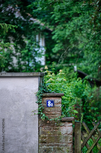 Detail of two garden walls standing beside each other with an idyllic green garden in the background © franconiaphoto