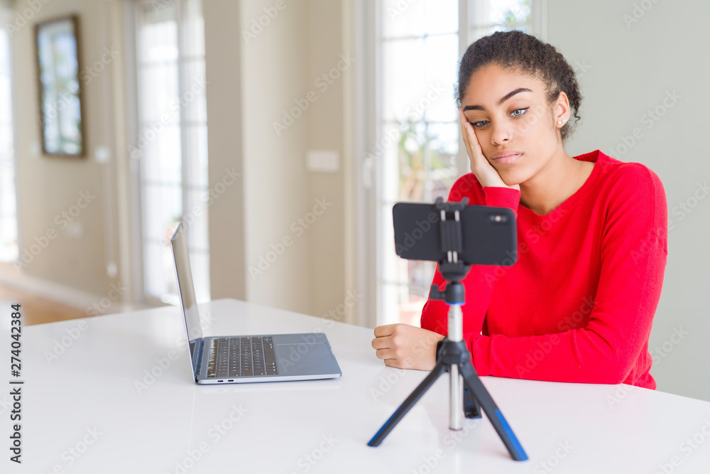 Young african american woman doing video call using smartphone camera thinking looking tired and bored with depression problems with crossed arms. Young african american woman doing video call using smartphone camera thinking looking tired and bored with depression problems with crossed arms.