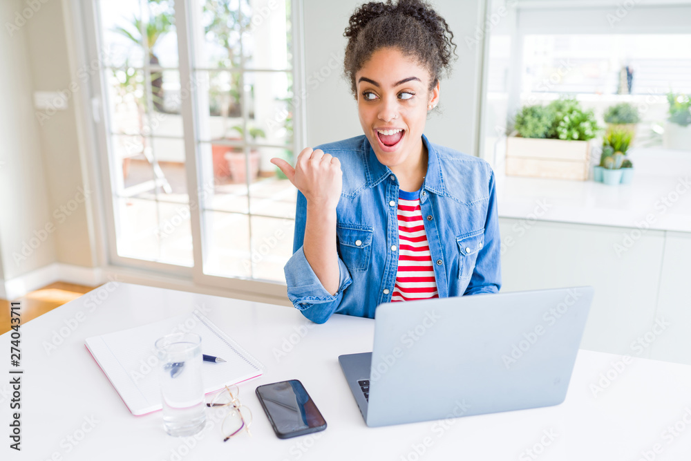 Young african american student woman using computer laptop pointing and ...