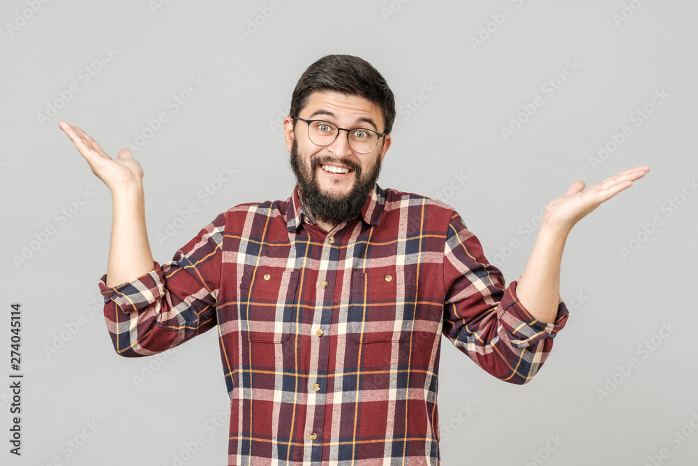 Portrait of handsome guy looking upside and shrugging his shoulders