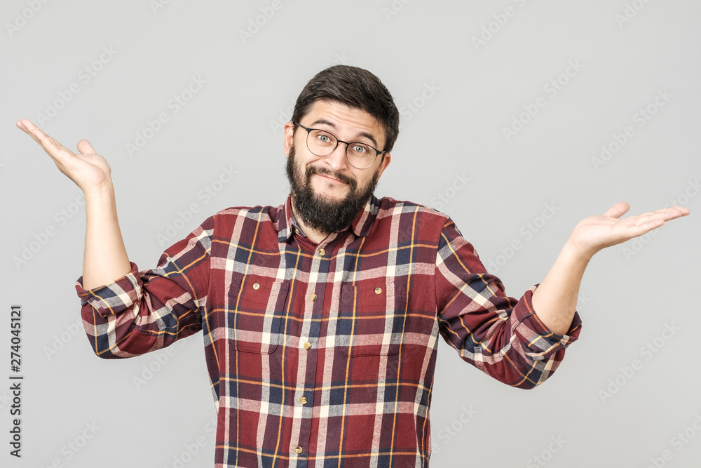 Portrait of handsome guy looking upside and shrugging his shoulders Portrait of handsome guy looking upside and shrugging his shoulders