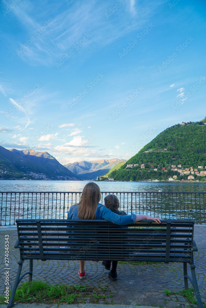 Woman and her daughter resting near the lake Como.